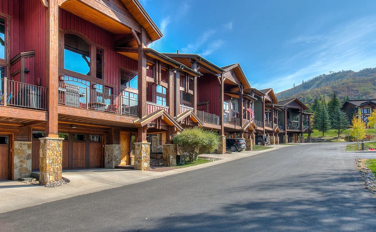 This exterior photo showcases Cimarron's signature wooden architecture, multiple balconies with railings, and a dramatic mountain backdrop. The setting is ideal for scenic walks, relaxing on balconies, and soaking in sunset views, all while immersed in alpine beauty.