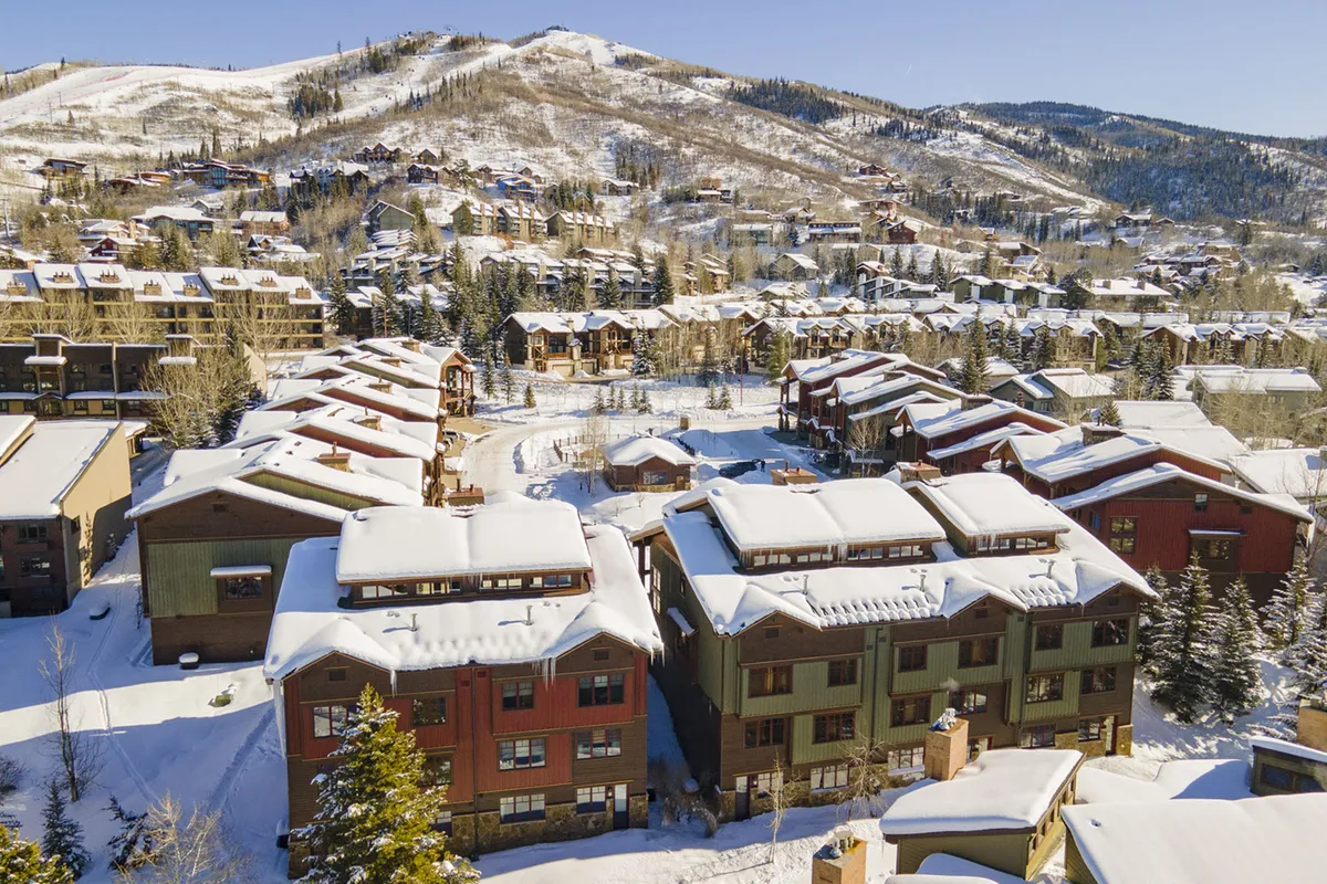 A sweeping exterior shot that frames Cimarron’s snow-capped rooftops amid towering trees and a striking mountain backdrop. The atmosphere is festive yet peaceful, with clear hints of the outdoor activities available to guests.