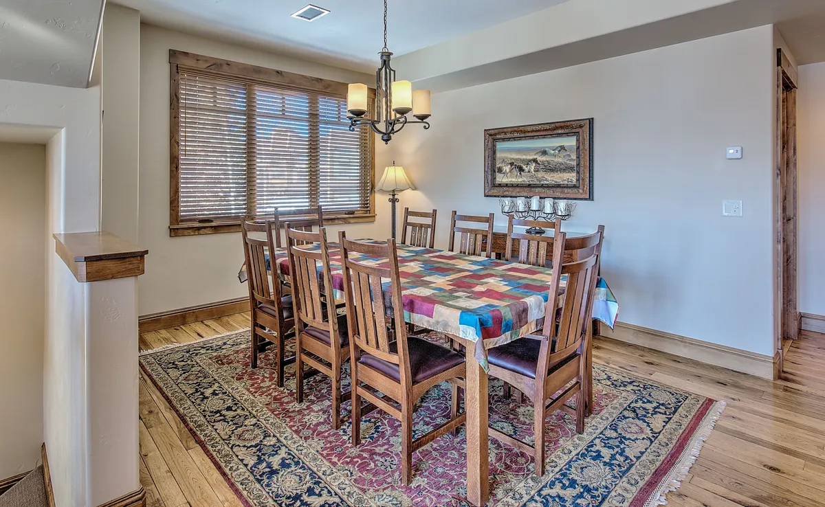 An inviting dining area with a wooden table and chairs, warm lighting, and tasteful decor. The setup suggests intimate dinners, festive celebrations, and lively game nights—activities central to group retreats and in-home relaxation after a day of adventure.